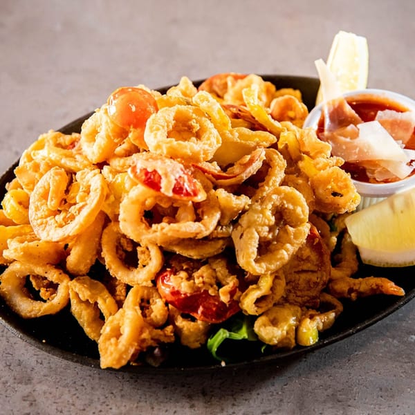Crispy fried calamari and shrimp with cherry tomatoes, lemon wedges, and marinara sauce.
